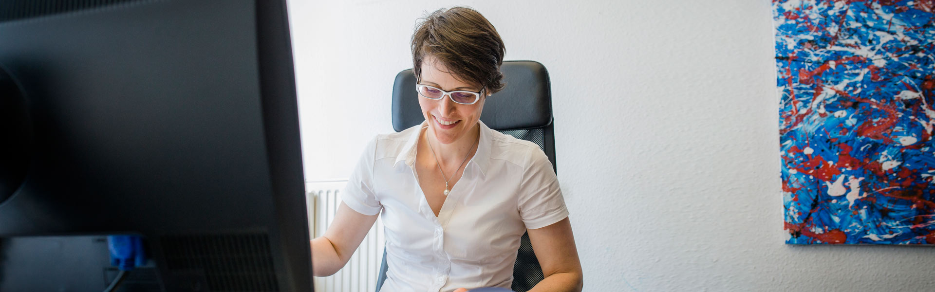 Steuerberater schaut in die Kamera während eine Frau hinter ihm steht